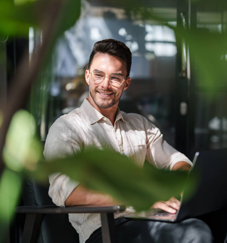 Man with glasses smiling sat down