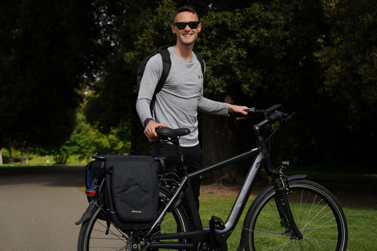 Man standing next to a bike smiling