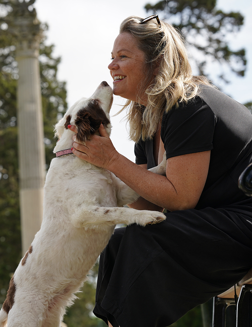 A women hugging her dog and smiling